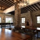 Restaurante de la hacienda con muros de piedra, vigas de madera y mesas para recepción
