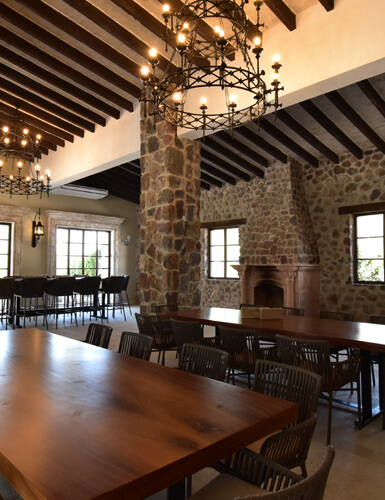 Restaurante de la hacienda con muros de piedra, vigas de madera y mesas para recepción